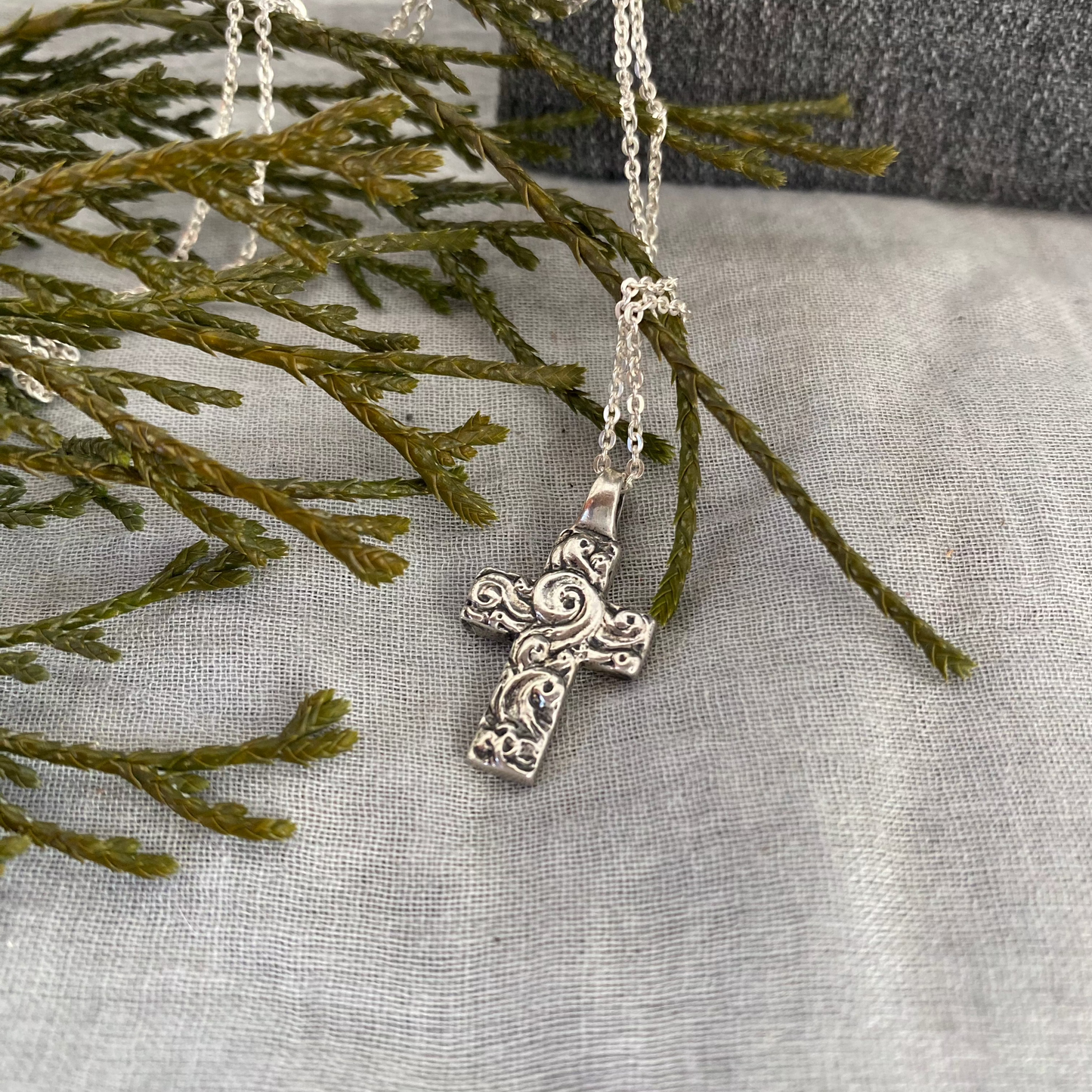 Chunky sterling silver cross necklace with swirling wave design on sterling silver chain