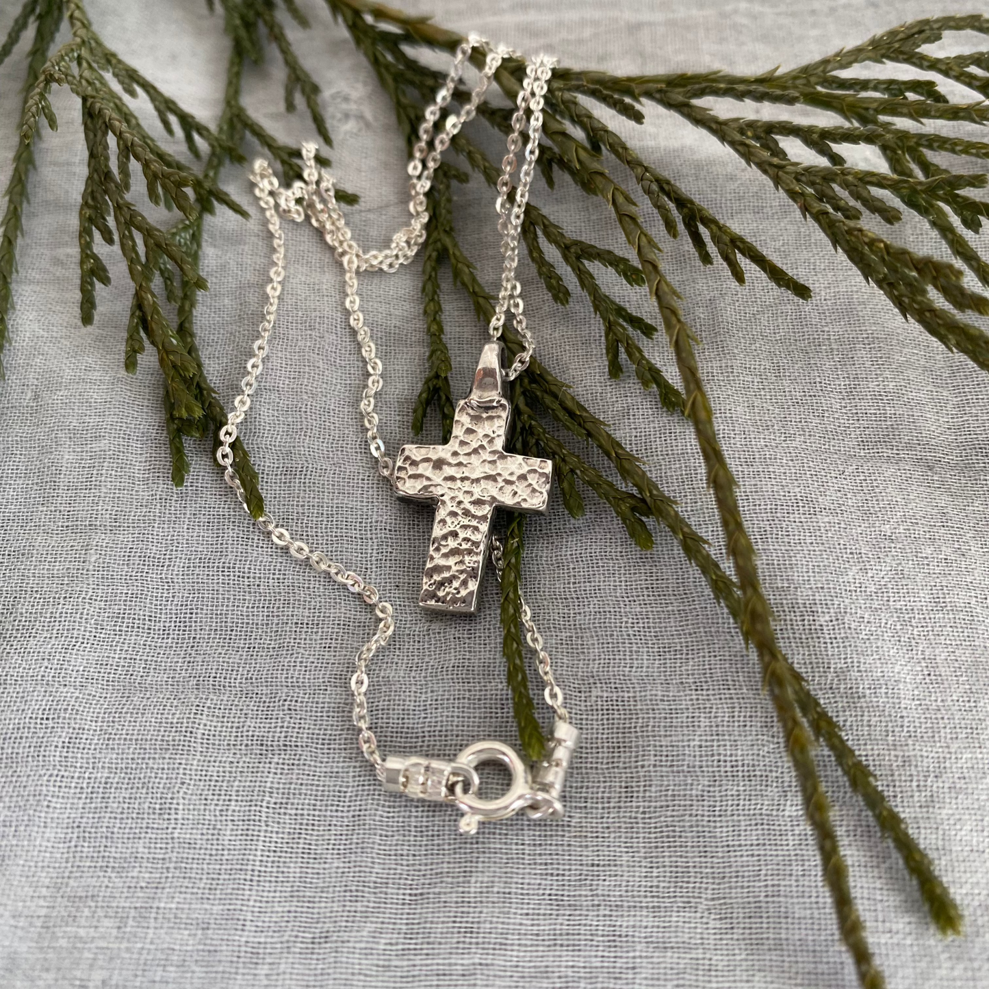 Chunky sterling silver cross necklace with swirling wave design on sterling silver chain