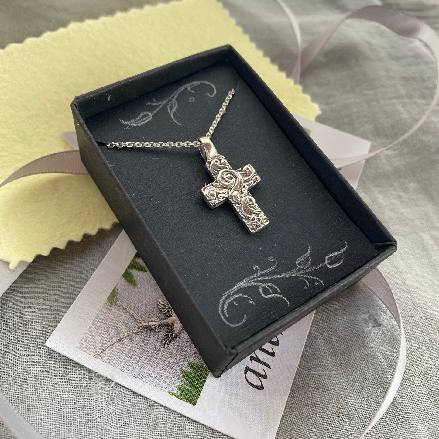 Chunky sterling silver cross necklace with swirling wave design on sterling silver chain