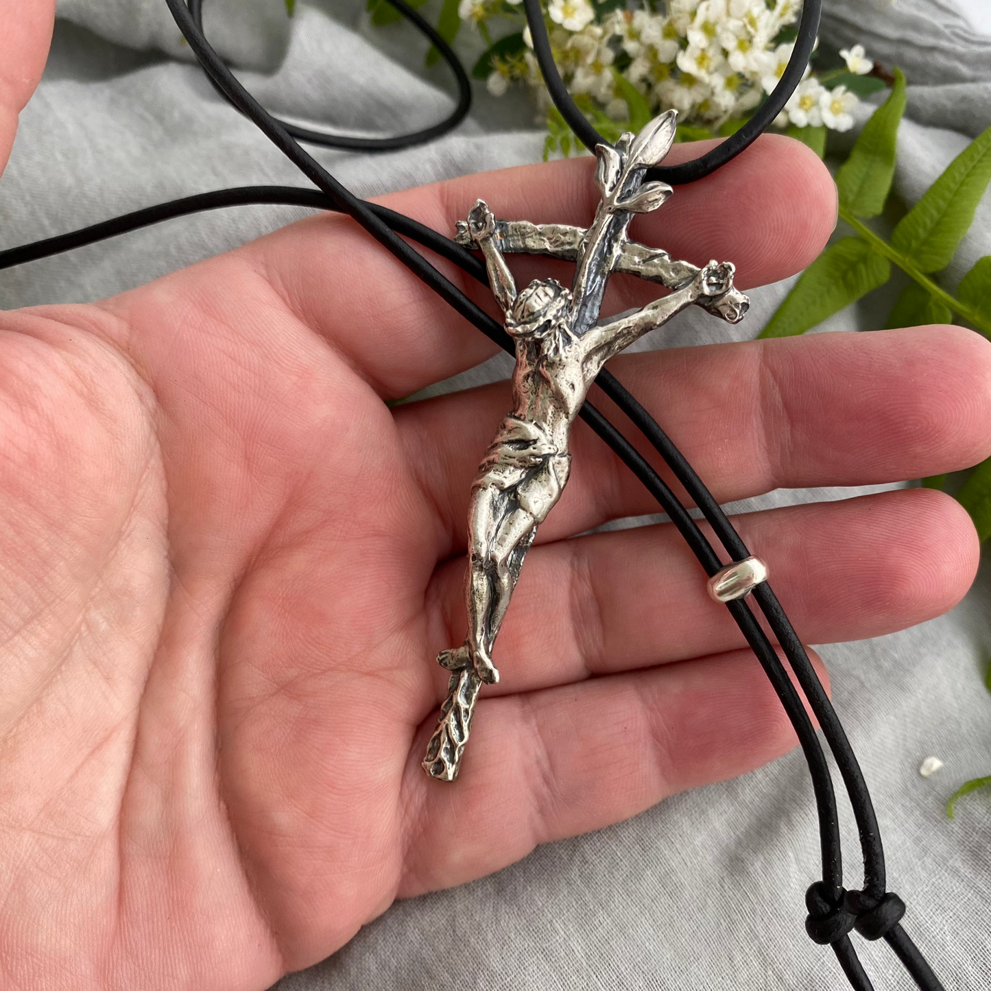 large sterling silver crucifix on black leather cord with realistic corpus and leeaves