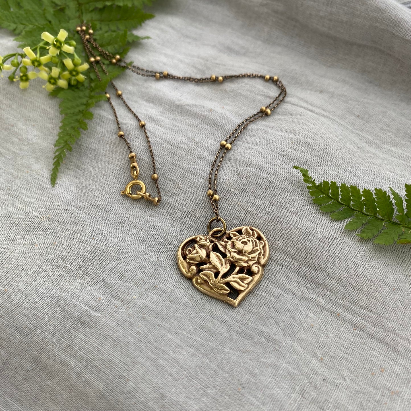 Richly carved Victorian-style brass heart necklace with roses on antiqued brass satellite cable chain
