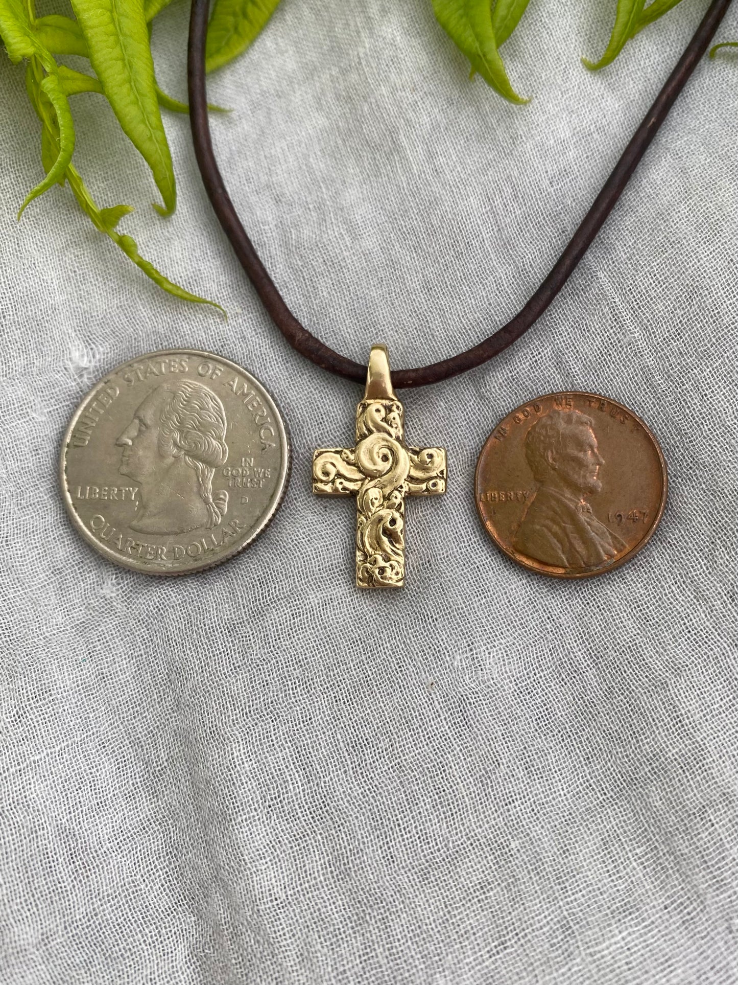chunky small brass cross on brown leather cord with unique swirling wave design, gift for men and women, hand carved and produced in USA