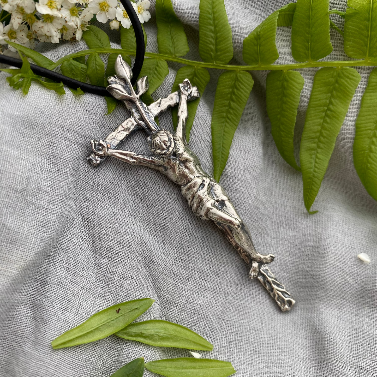 large sterling silver crucifix on black leather cord with realistic corpus and leeaves