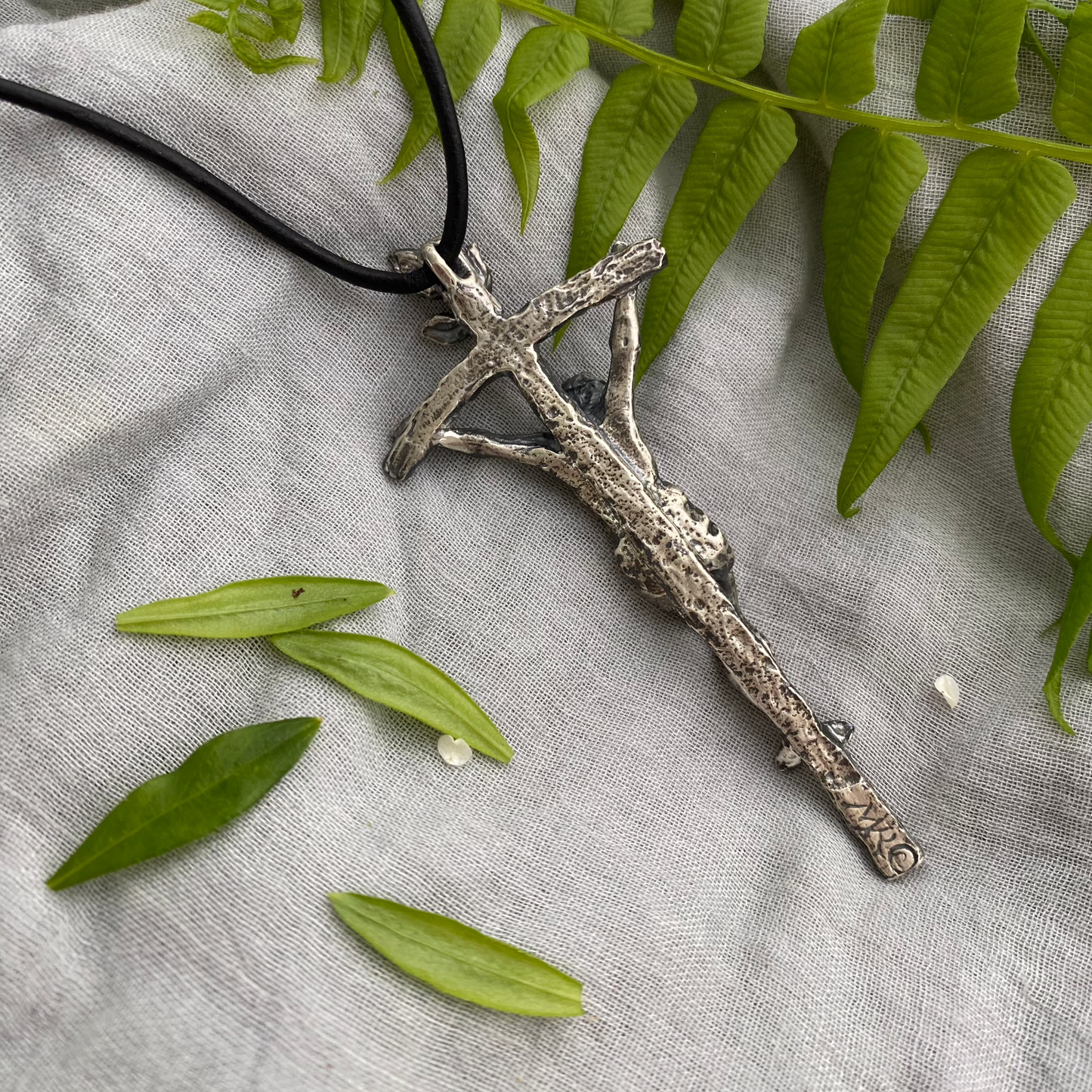 large sterling silver crucifix on black leather cord with realistic corpus and leeaves