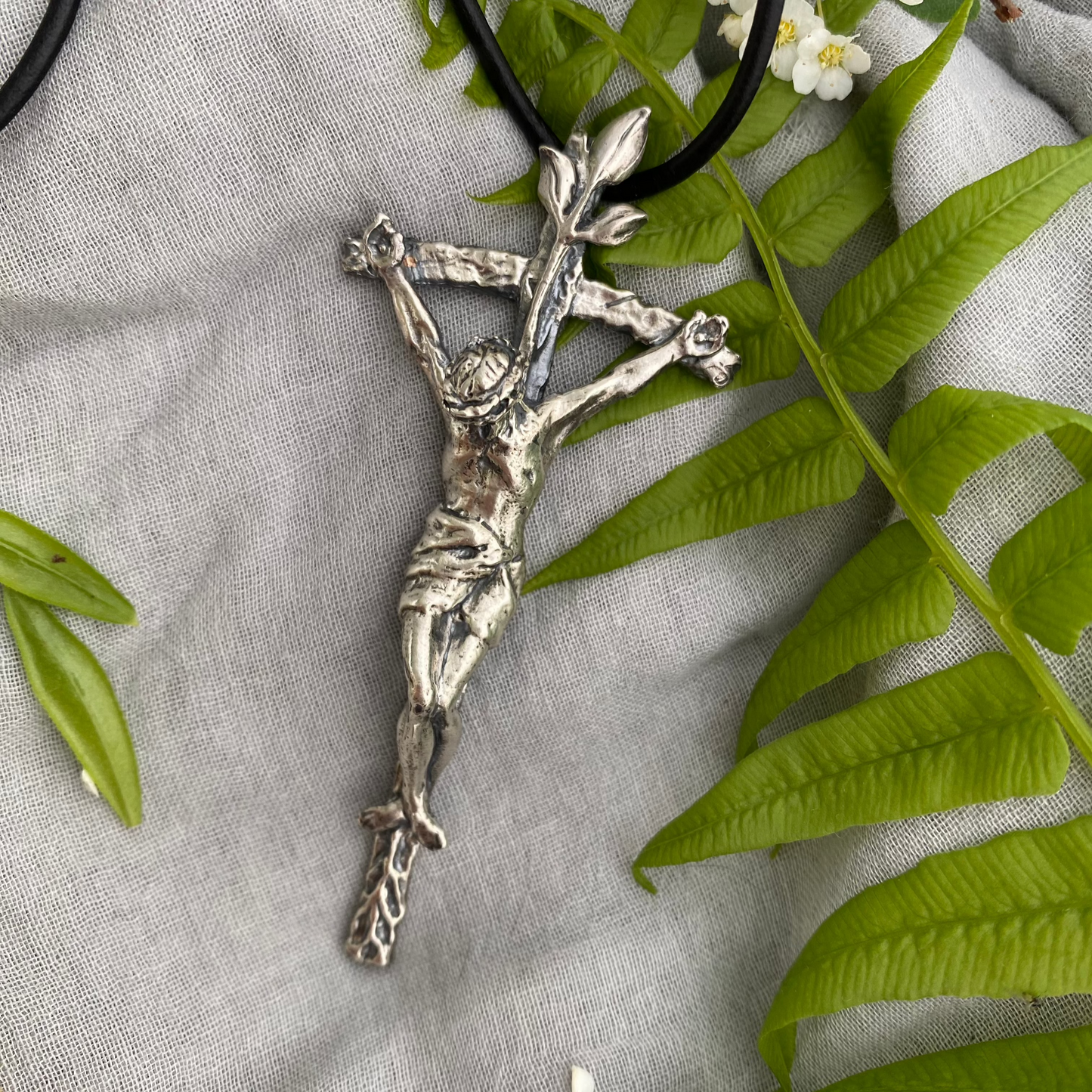 large sterling silver crucifix on black leather cord with realistic corpus and leeaves