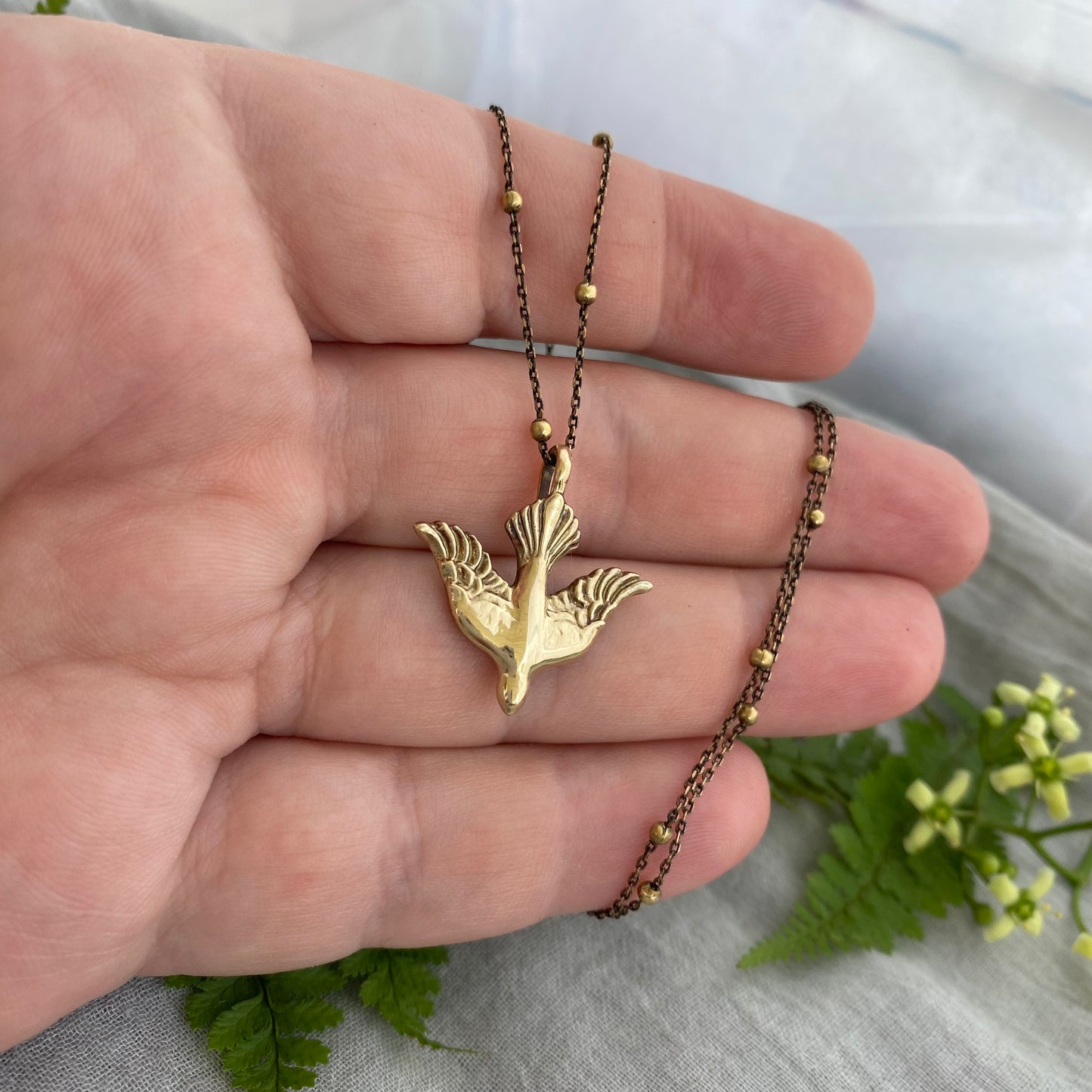 Holy Spirit peace dove pendant necklace gold toned brass dove and chain. It is just under an inch wide and almost an inch long.