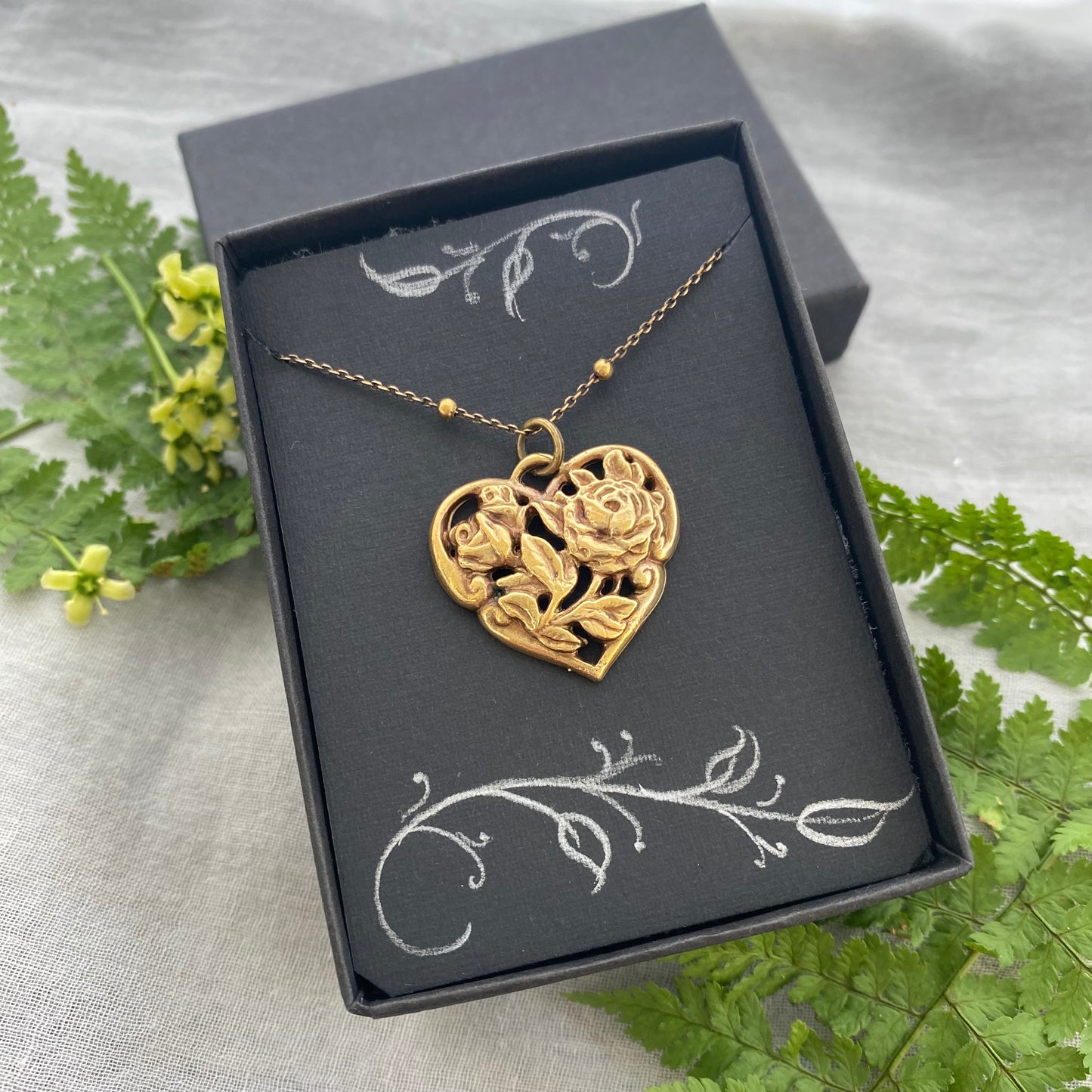 Richly carved Victorian-style brass heart necklace with roses on antiqued brass satellite cable chain