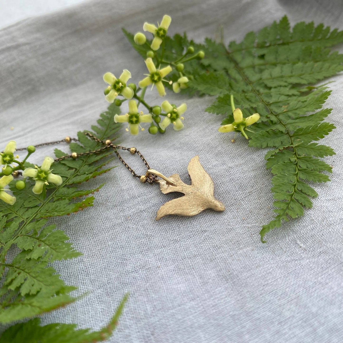 Holy Spirit peace dove pendant necklace gold toned brass dove and chain. It is just under an inch wide and almost an inch long.