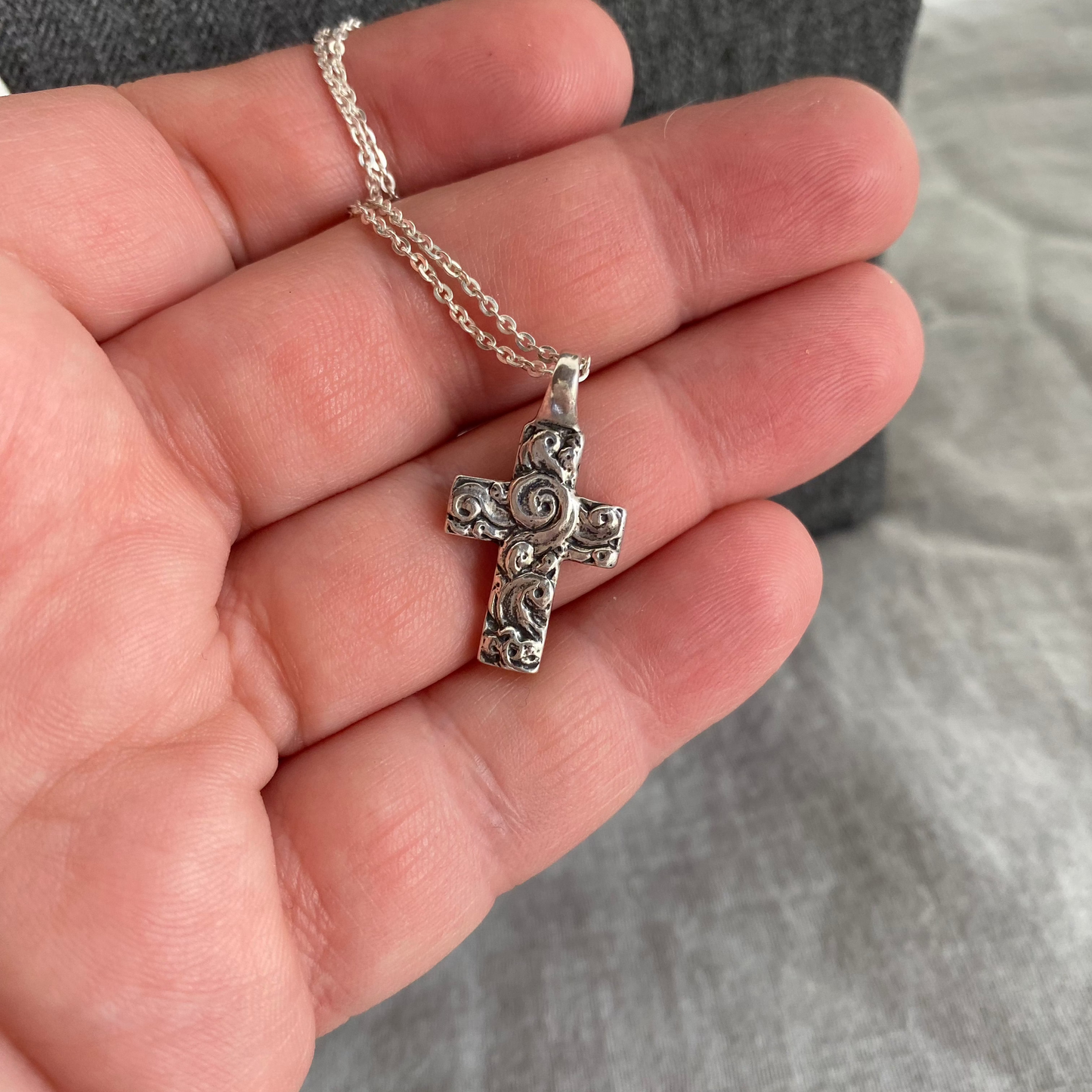 Chunky sterling silver cross necklace with swirling wave design on sterling silver chain