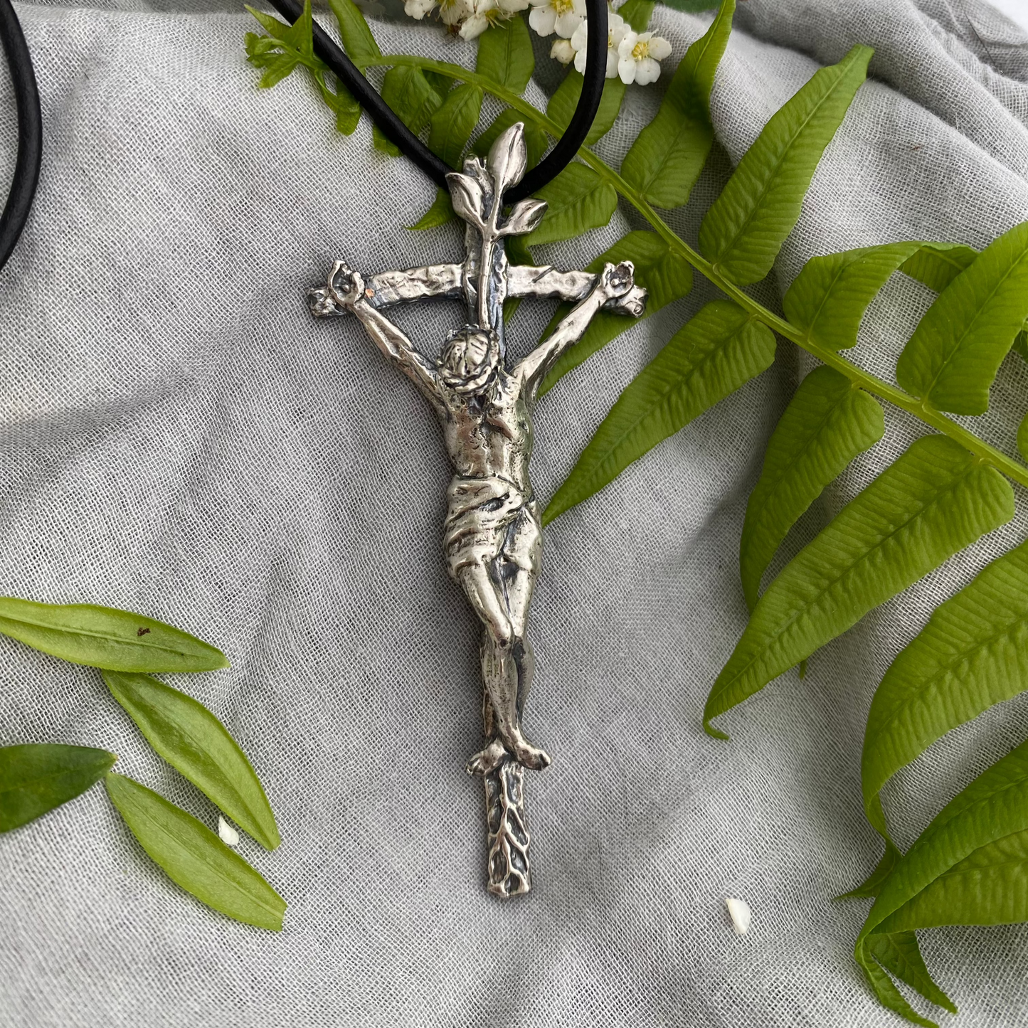 large sterling silver crucifix on black leather cord with realistic corpus and leeaves