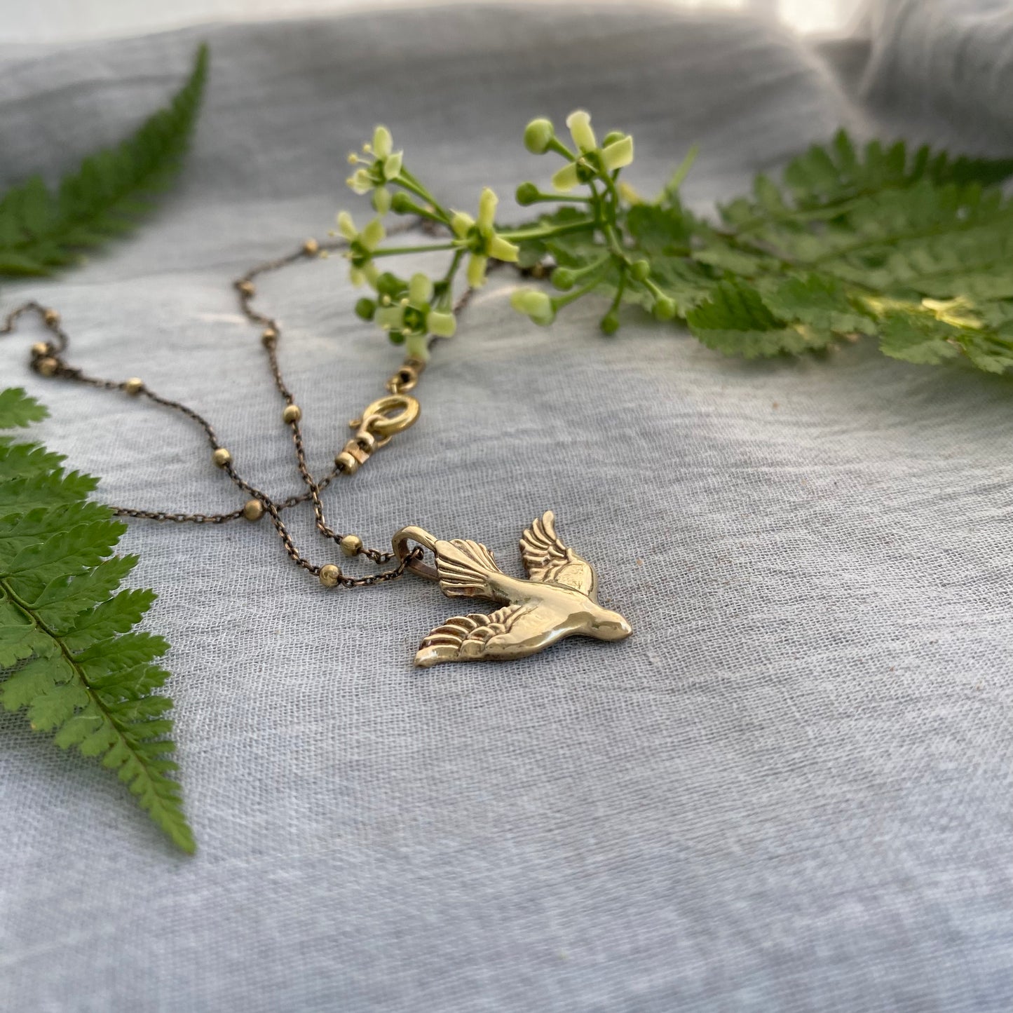 Holy Spirit peace dove pendant necklace gold toned brass dove and chain. It is just under an inch wide and almost an inch long.