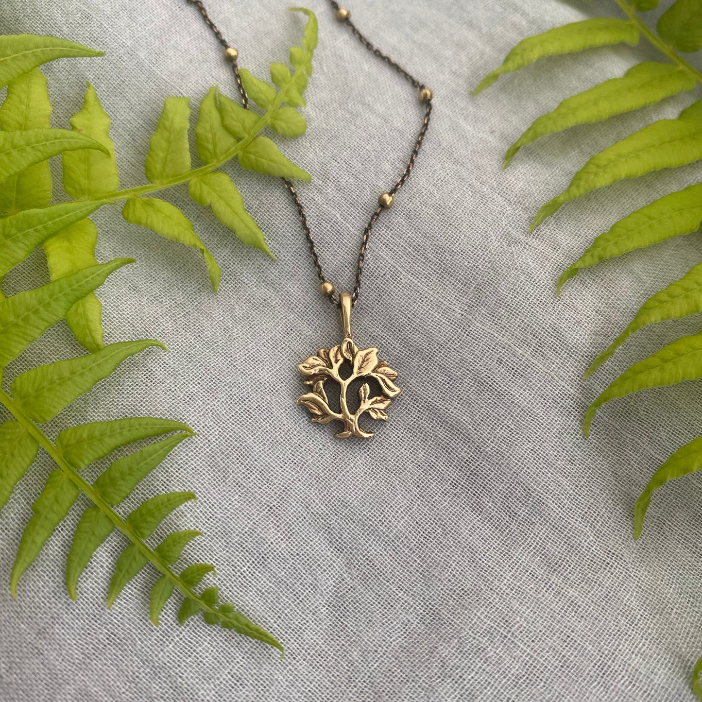 dainty gold-toned tree of life necklace; tiny antiqued brass pendant and chain; gift for nature lover; mythological and Christian symbol