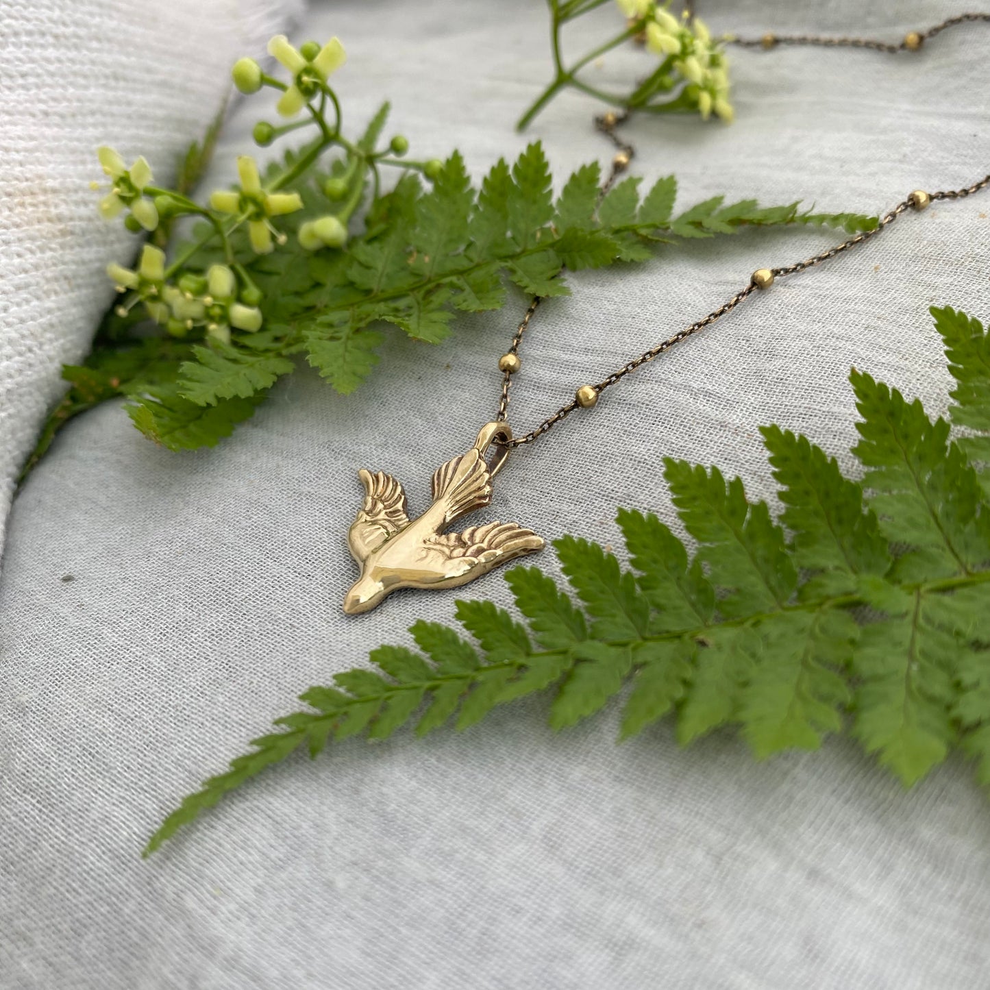 Holy Spirit peace dove pendant necklace gold toned brass dove and chain. It is just under an inch wide and almost an inch long.