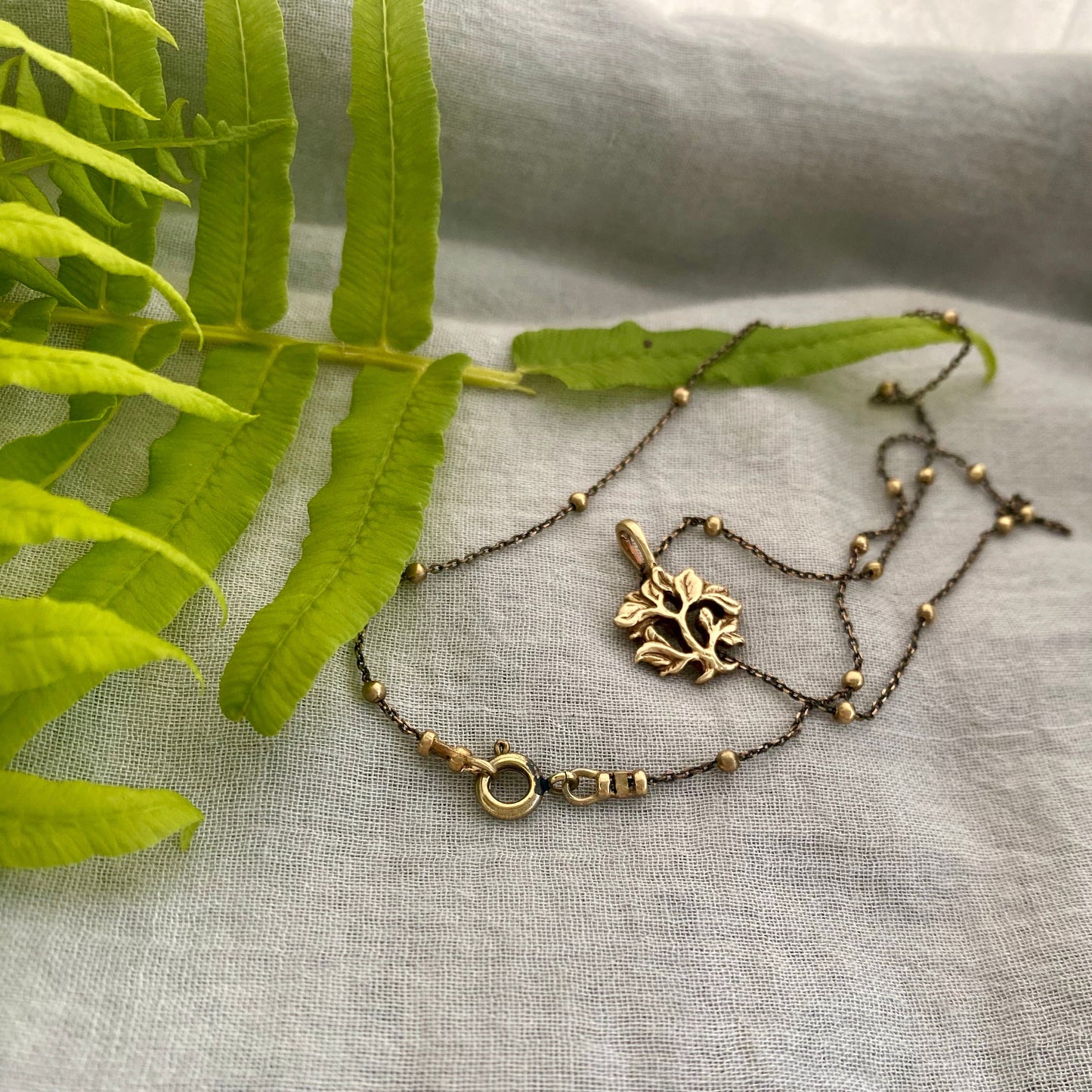 dainty gold-toned tree of life necklace; tiny antiqued brass pendant and chain; gift for nature lover; mythological and Christian symbol