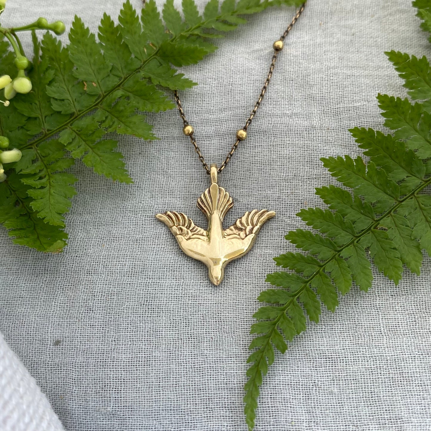 Holy Spirit peace dove pendant necklace gold toned brass dove and chain. It is just under an inch wide and almost an inch long.
