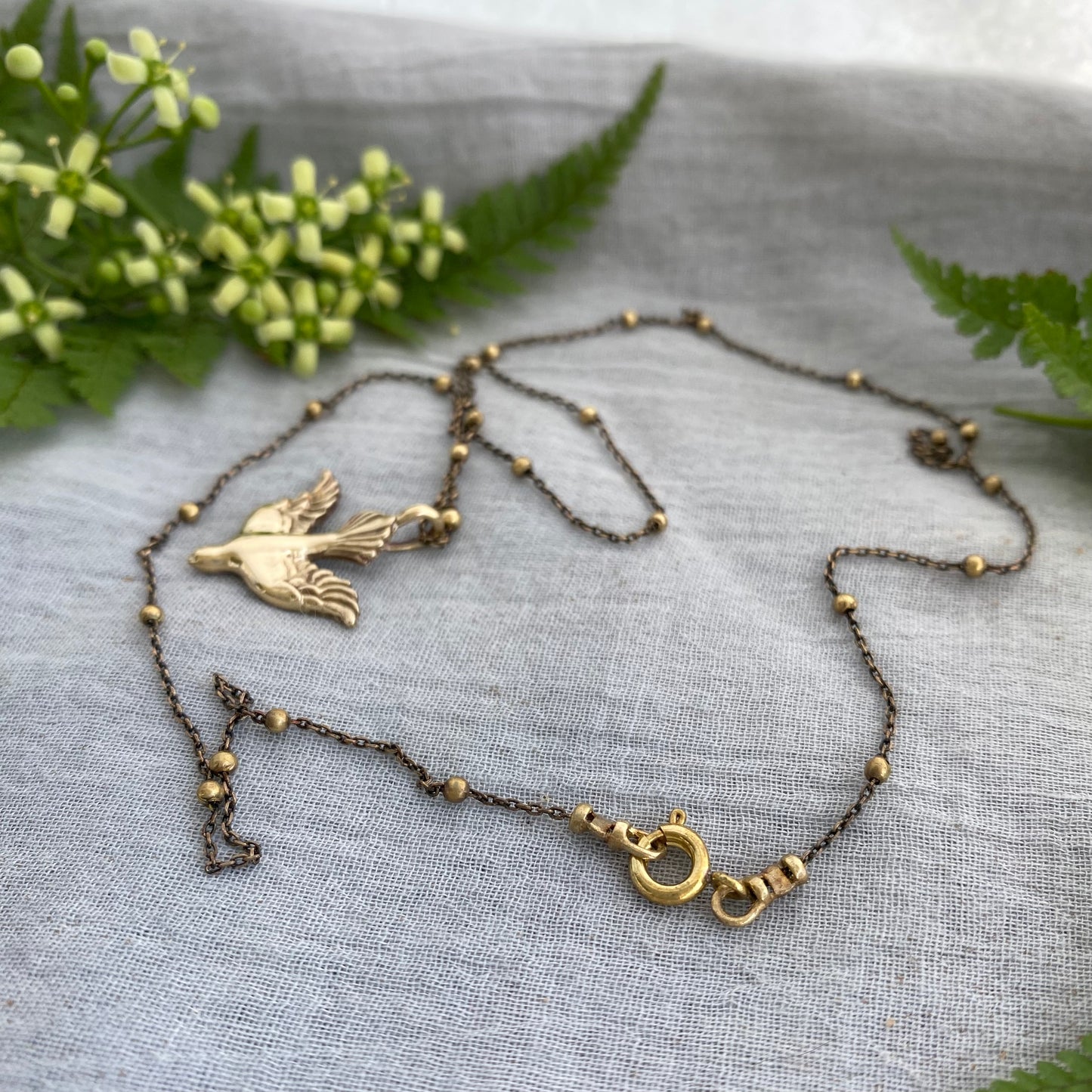 Holy Spirit peace dove pendant necklace gold toned brass dove and chain. It is just under an inch wide and almost an inch long.