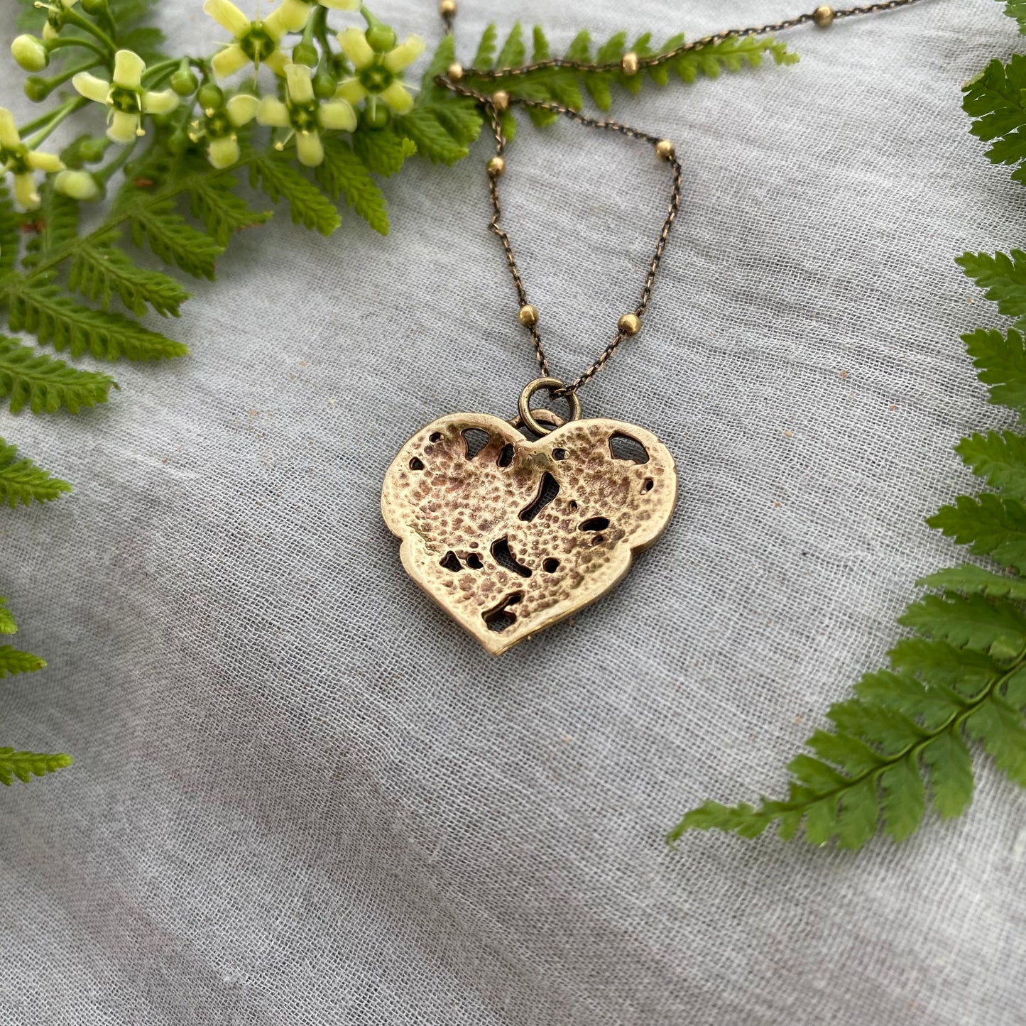 Richly carved Victorian-style brass heart necklace with roses on antiqued brass satellite cable chain