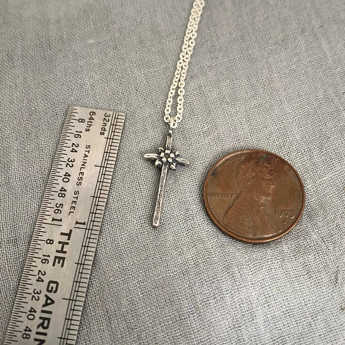 dainty sterling silver cross necklace with tiny flower and leaves