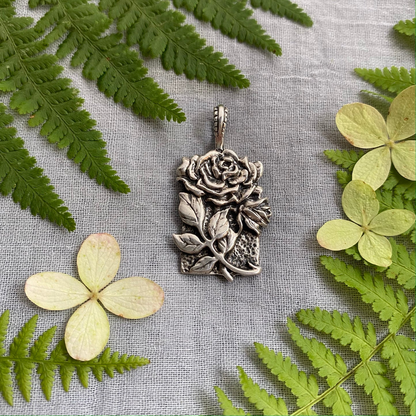 Sculptural silver rose pendant with rosebuds and leaves