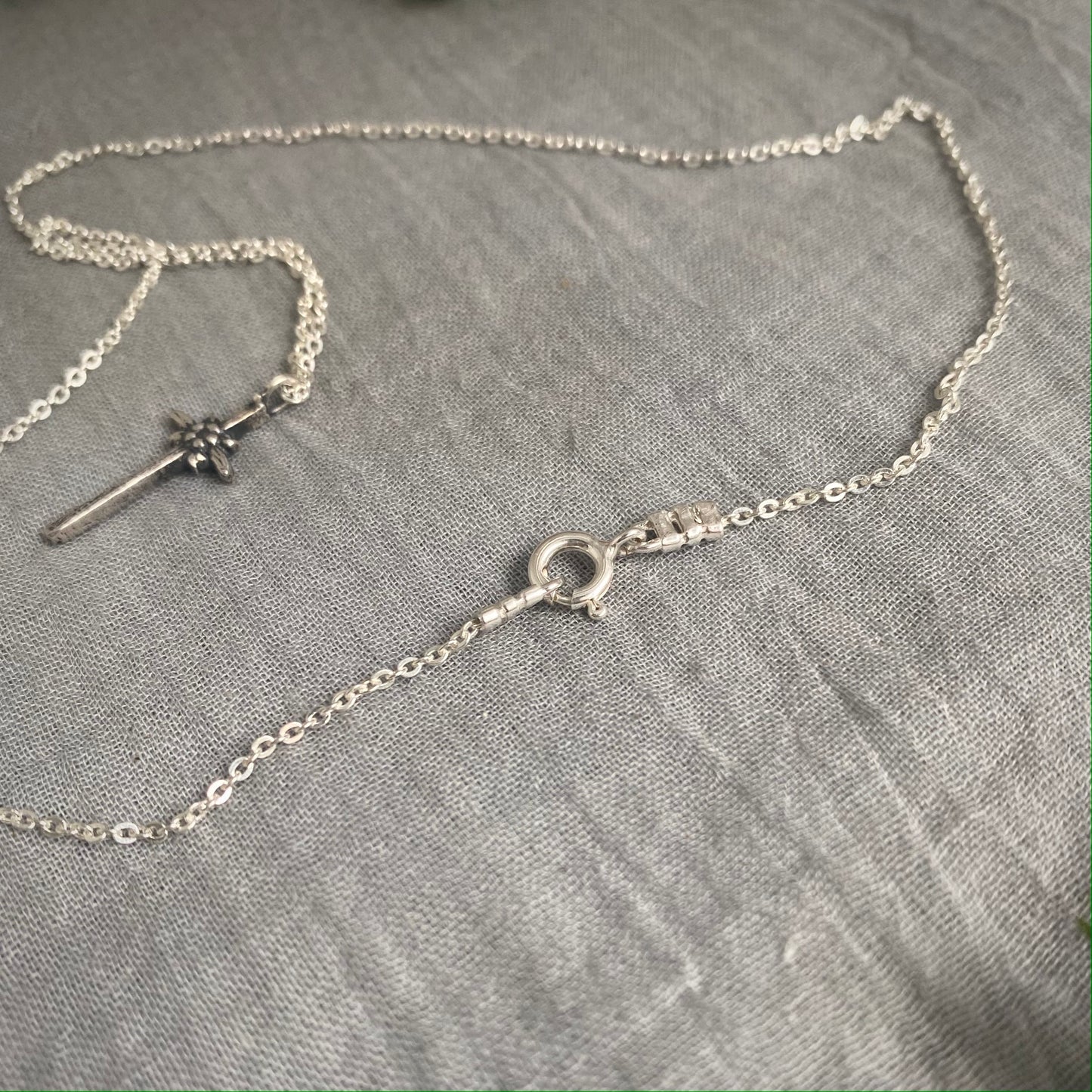 dainty sterling silver cross necklace with tiny flower and leaves