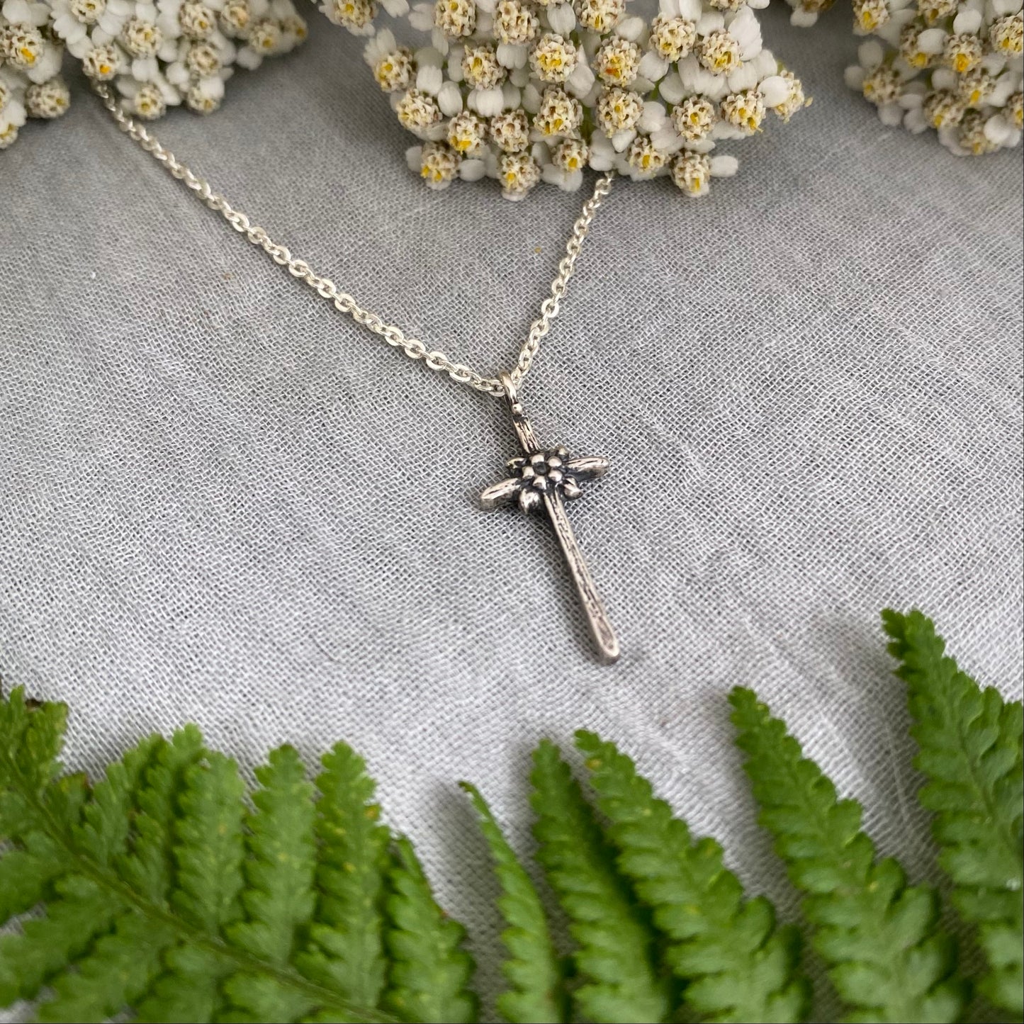 dainty sterling silver cross necklace with tiny flower and leaves