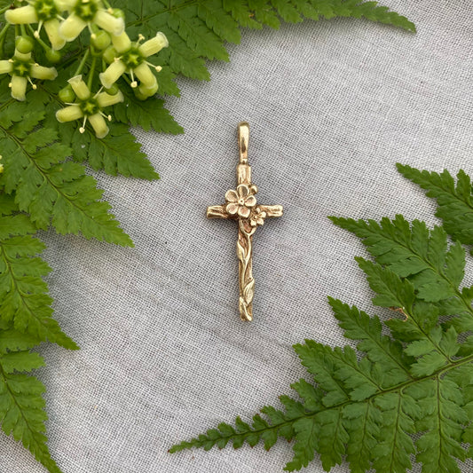 Dainty floral cross pendant for a necklace; gold toned brass; forget-me-not blossoms, leaves, wood grain texture; feminine flower; no chain