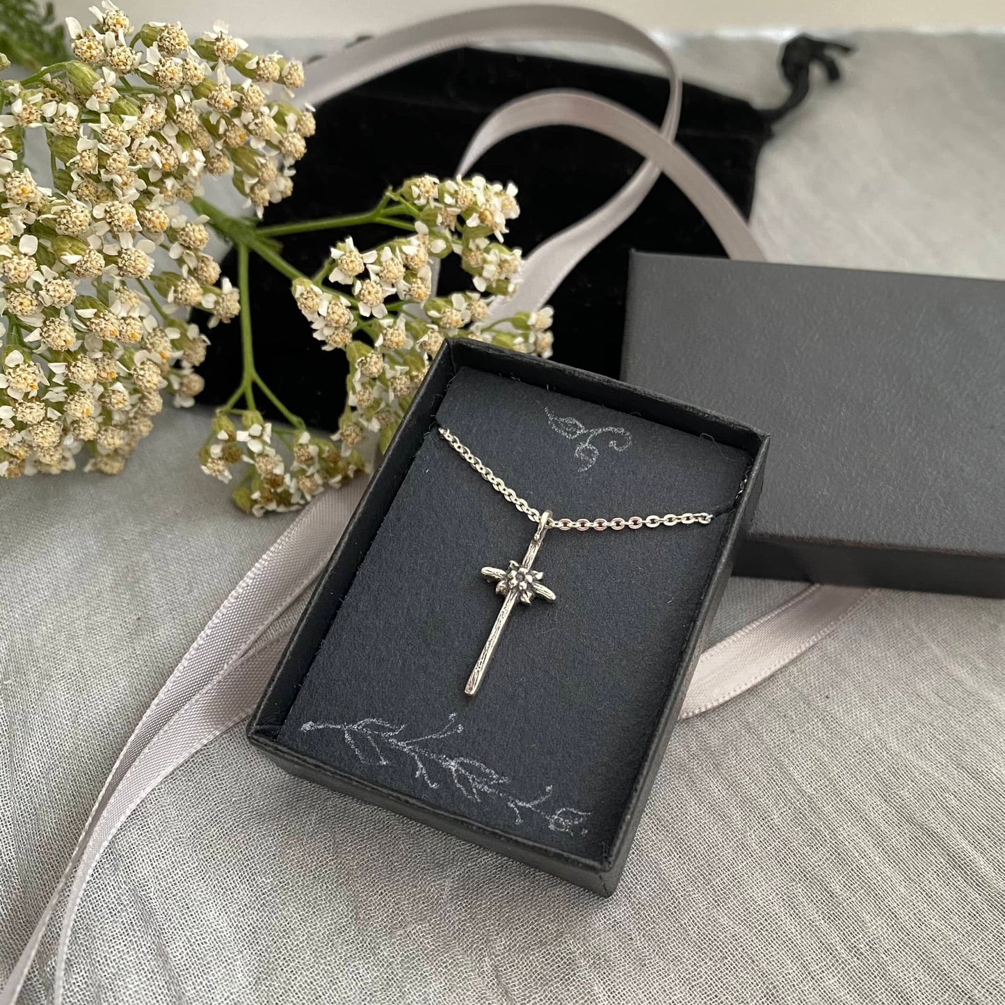 dainty sterling silver cross necklace with tiny flower and leaves