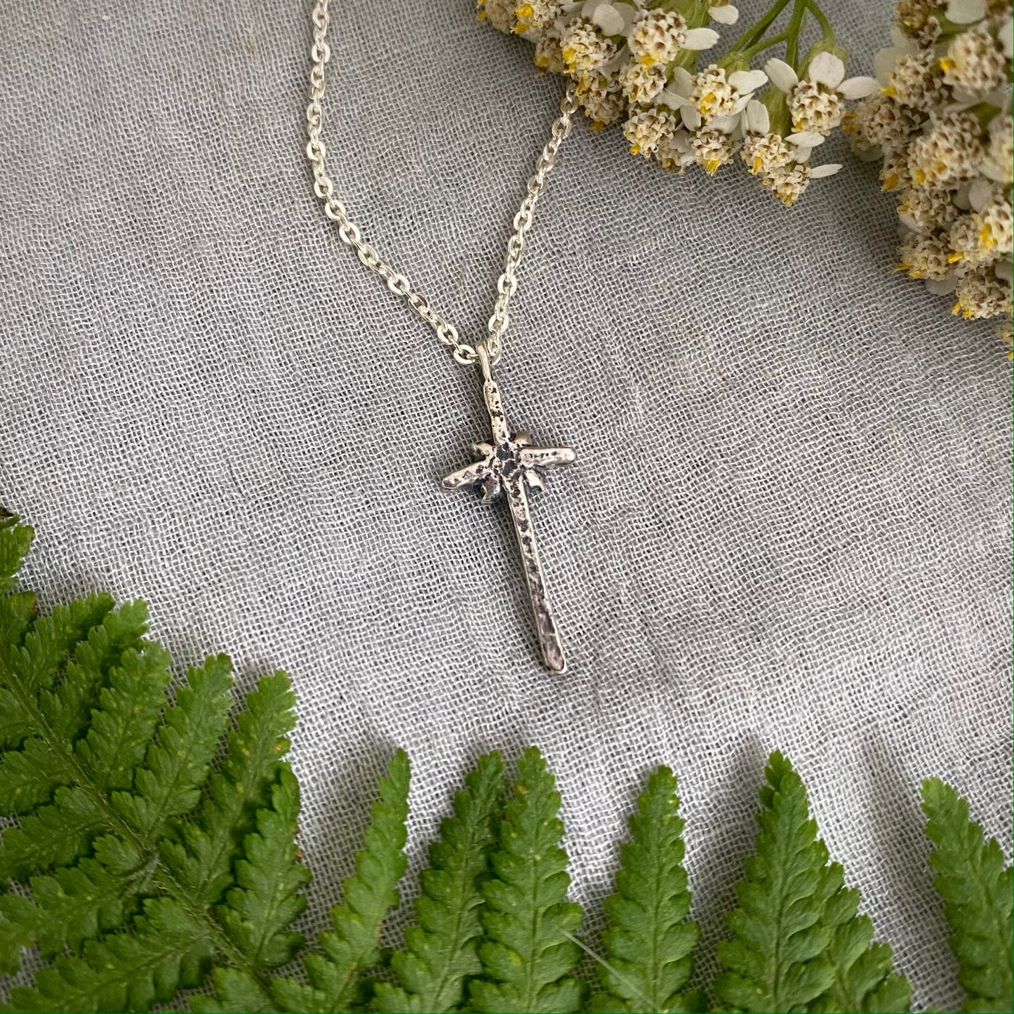 dainty sterling silver cross necklace with tiny flower and leaves