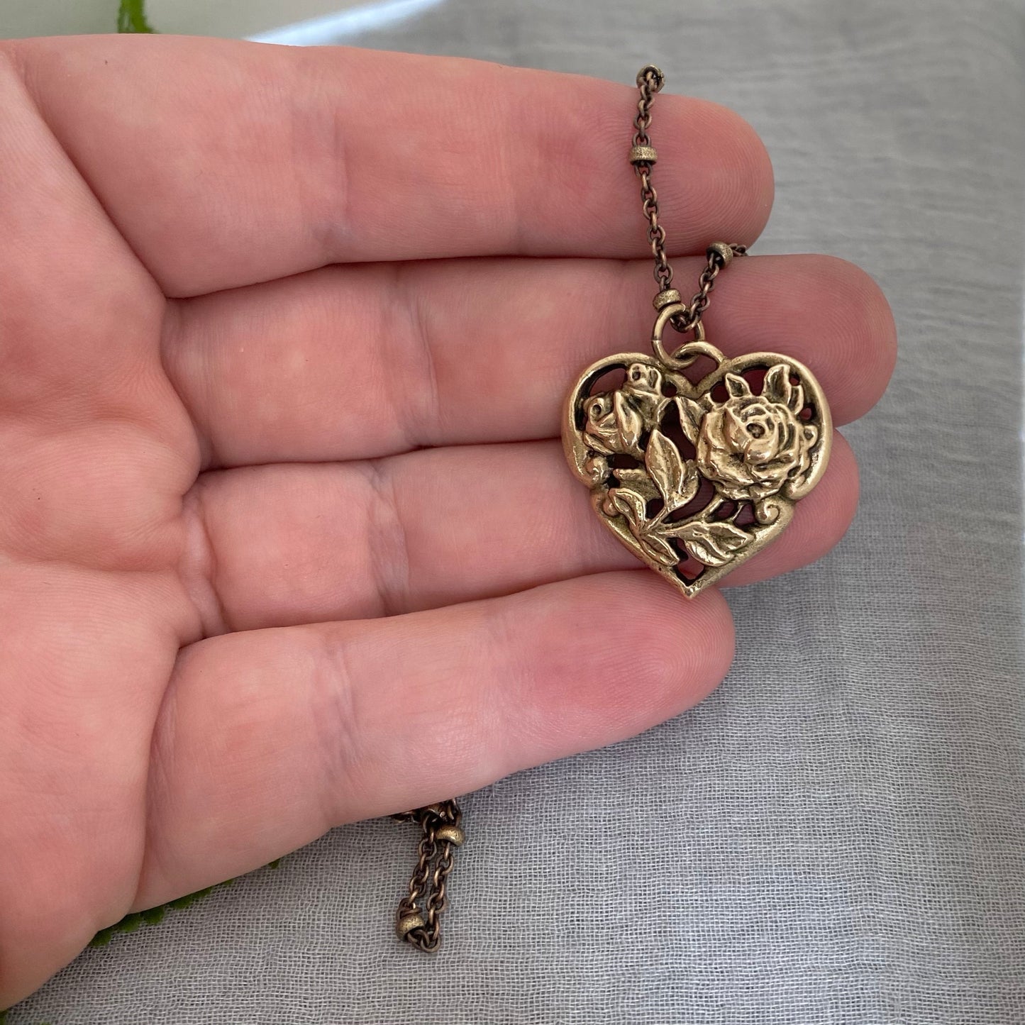 Brass floral heart necklace on satellite chain