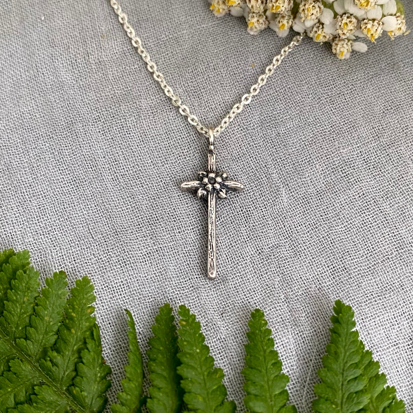 dainty sterling silver cross necklace with tiny flower and leaves