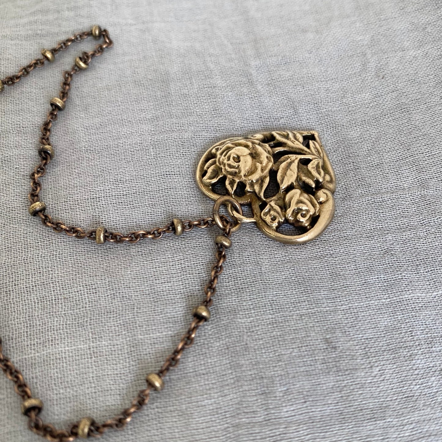 Brass floral heart necklace on satellite chain