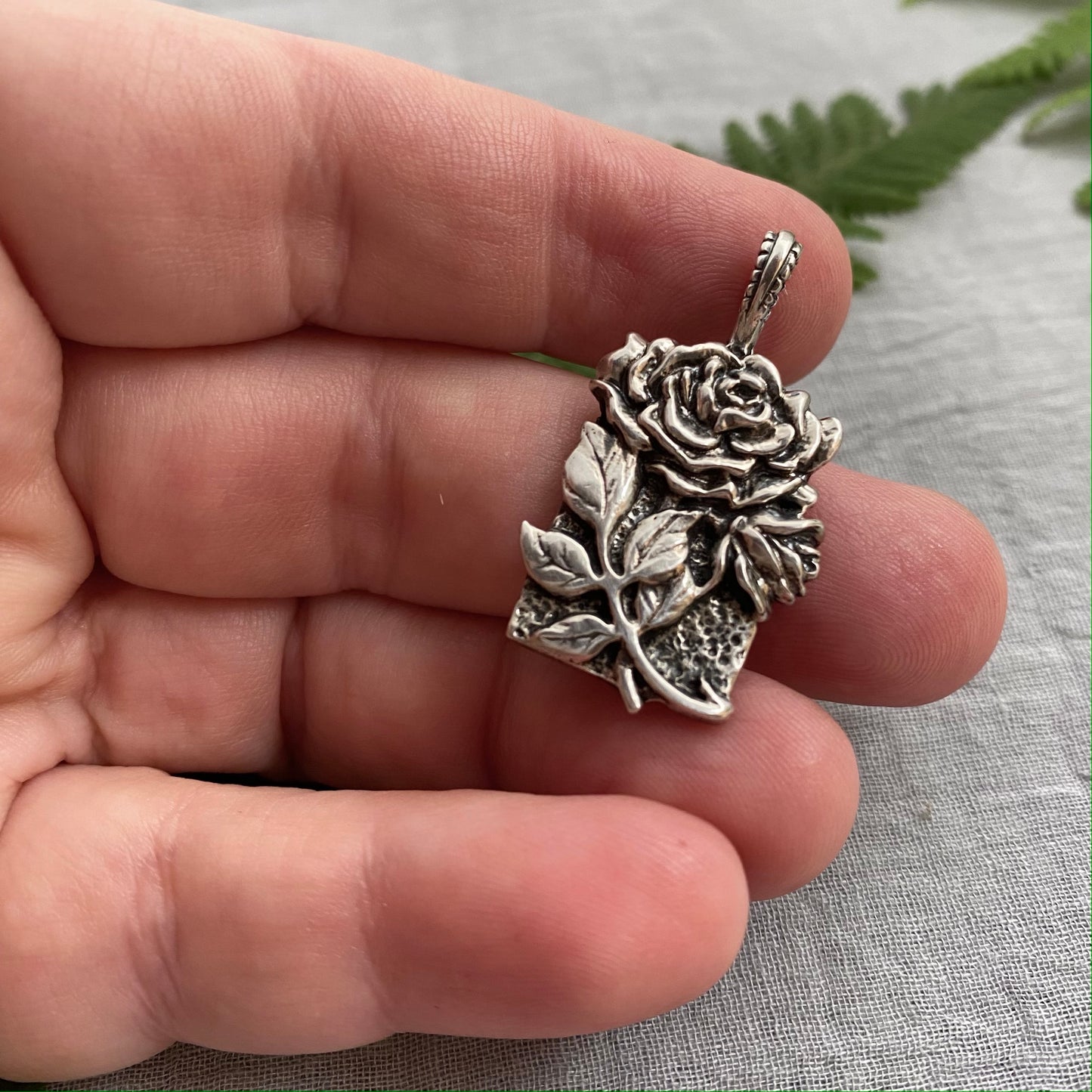 Sculptural silver rose pendant with rosebuds and leaves